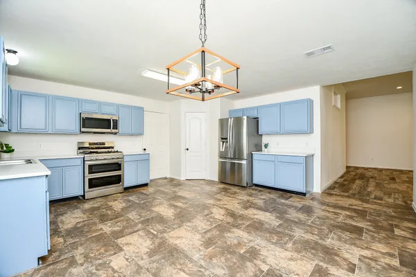 a kitchen with stainless steel appliances a stove a refrigerator sink and microwave