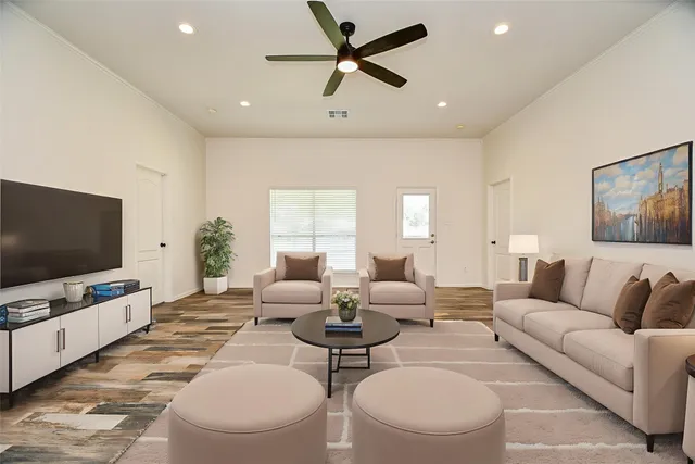 a living room with furniture a flat screen tv and a window