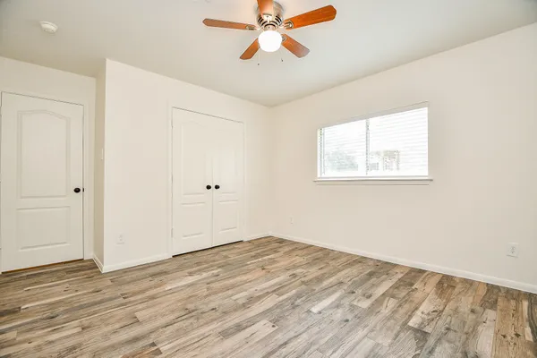 a view of empty room with wooden floor