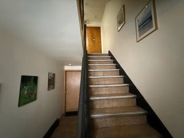 a view of staircase with lots of frames on wall