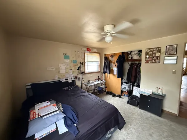 a bed room with a bed and a ceiling fan