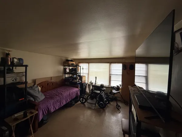 a bedroom with furniture and large windows