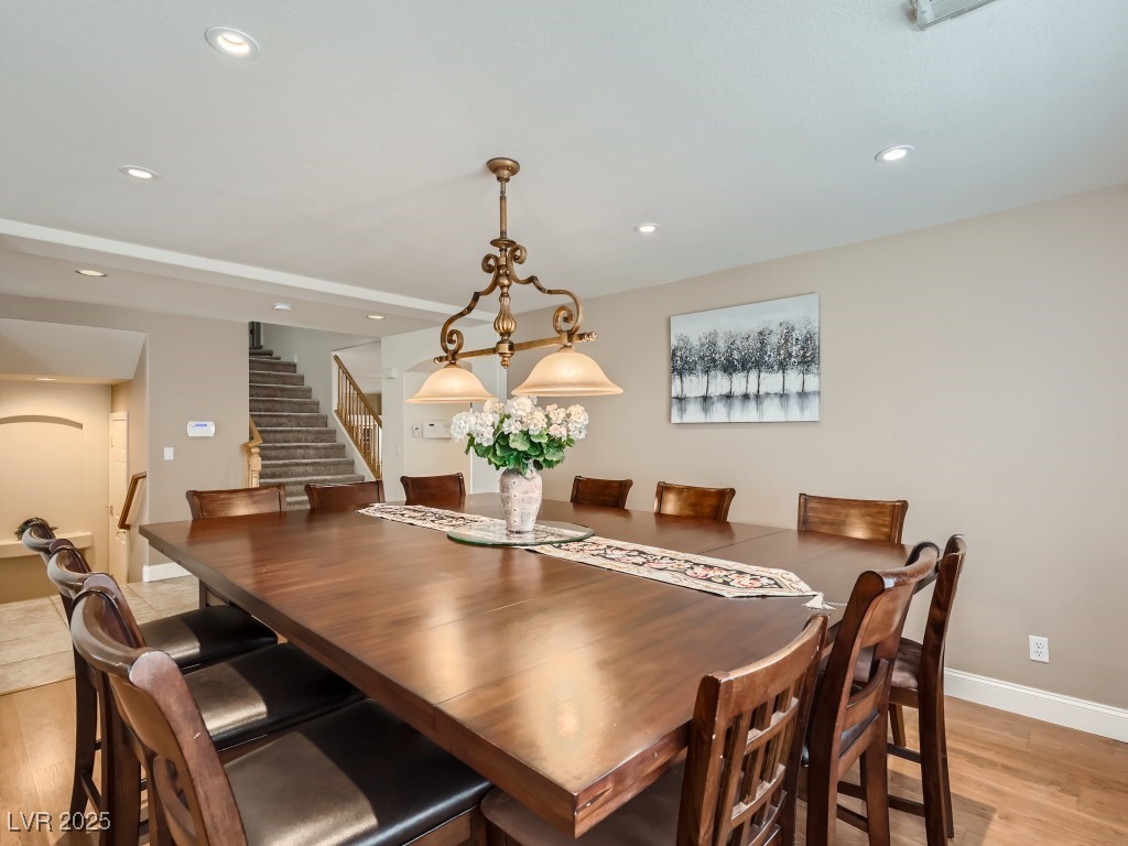 1221 Fragrant Spruce Avenue Las Vegas, NV 89123 - Photo 11 of 59 Dining area with wood-style floors, recessed lighting, chandelier, and stairway
