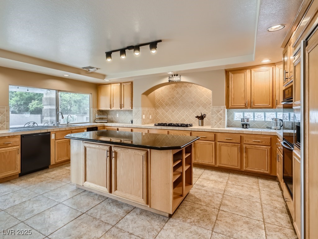 1221 Fragrant Spruce Avenue Las Vegas, NV 89123 - Photo 14 of 59 Kitchen featuring tasteful backsplash, a kitchen island, recessed lighting, a raised ceiling, and black appliances