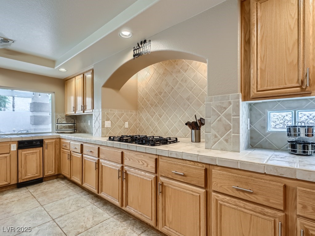 1221 Fragrant Spruce Avenue Las Vegas, NV 89123 - Photo 16 of 59 Kitchen featuring backsplash, recessed lighting, gas cooktop, light tile patterned flooring, and tile countertops