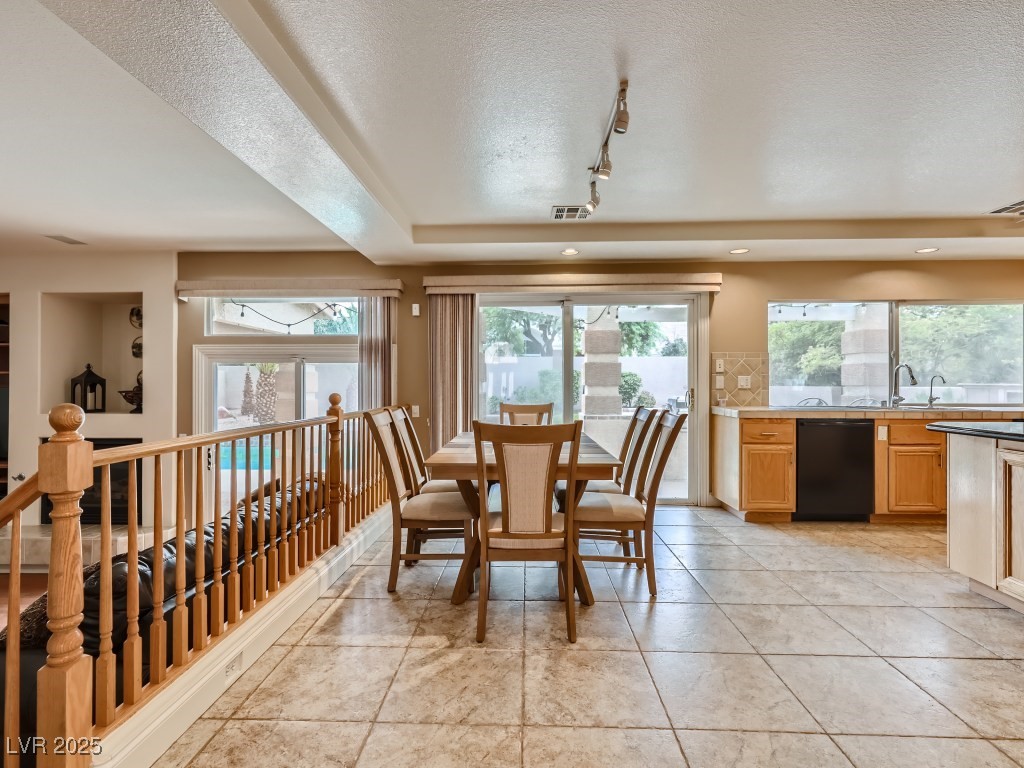1221 Fragrant Spruce Avenue Las Vegas, NV 89123 - Photo 17 of 59 Dining area featuring a textured ceiling, light tile patterned floors, and track lighting