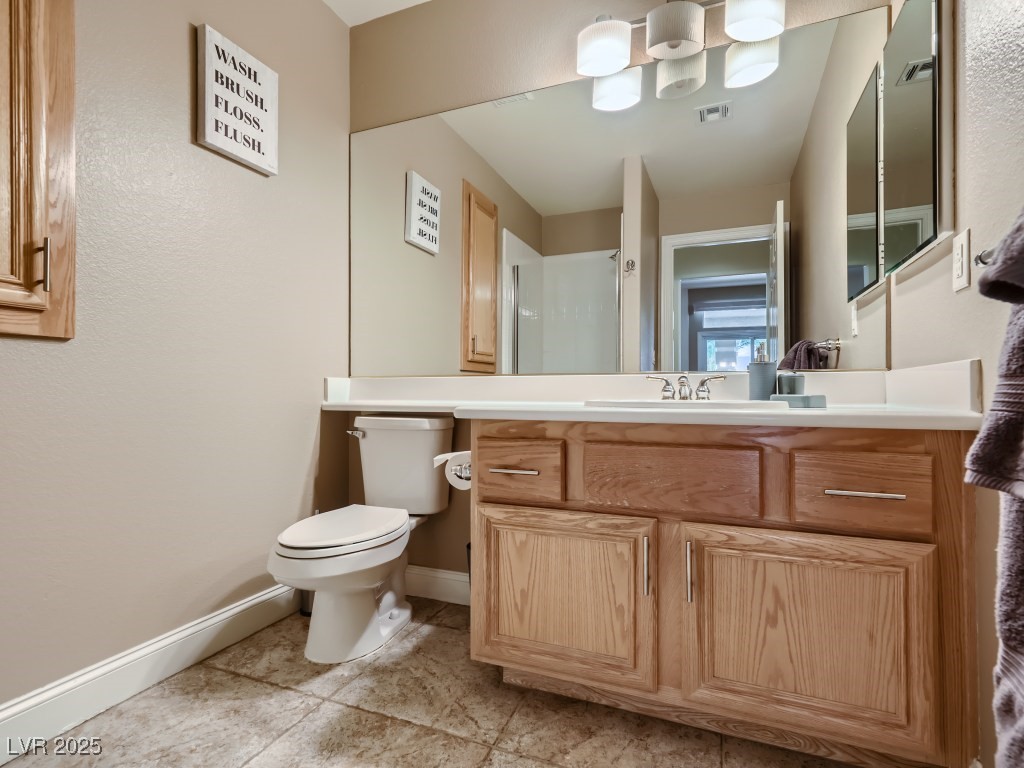 1221 Fragrant Spruce Avenue Las Vegas, NV 89123 - Photo 25 of 59 Full bathroom located downstairs featuring vanity, toilet, a shower, and light tile patterned flooring