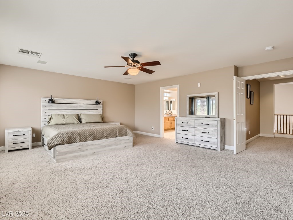 1221 Fragrant Spruce Avenue Las Vegas, NV 89123 - Photo 28 of 59 Primary bedroom with light carpet, full bath access, walk-in closet, and ceiling fan with light