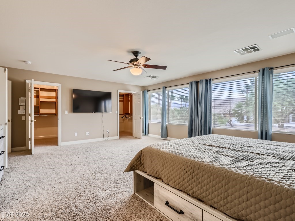 1221 Fragrant Spruce Avenue Las Vegas, NV 89123 - Photo 29 of 59 Primary bedroom with light carpet, full bath access, walk-in closet, and ceiling fan with light
