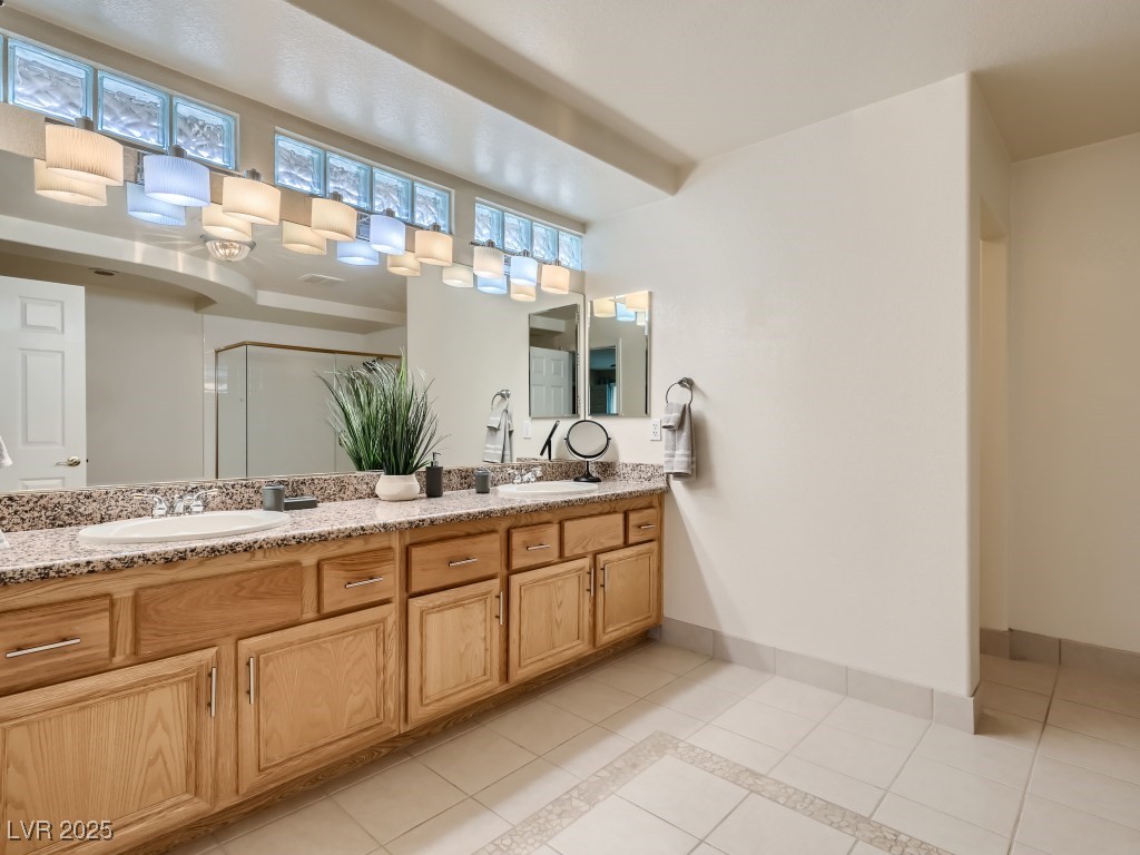 1221 Fragrant Spruce Avenue Las Vegas, NV 89123 - Photo 30 of 59 Bathroom featuring light tile patterned floors, double vanity, a shower stall, and inlaid floor details