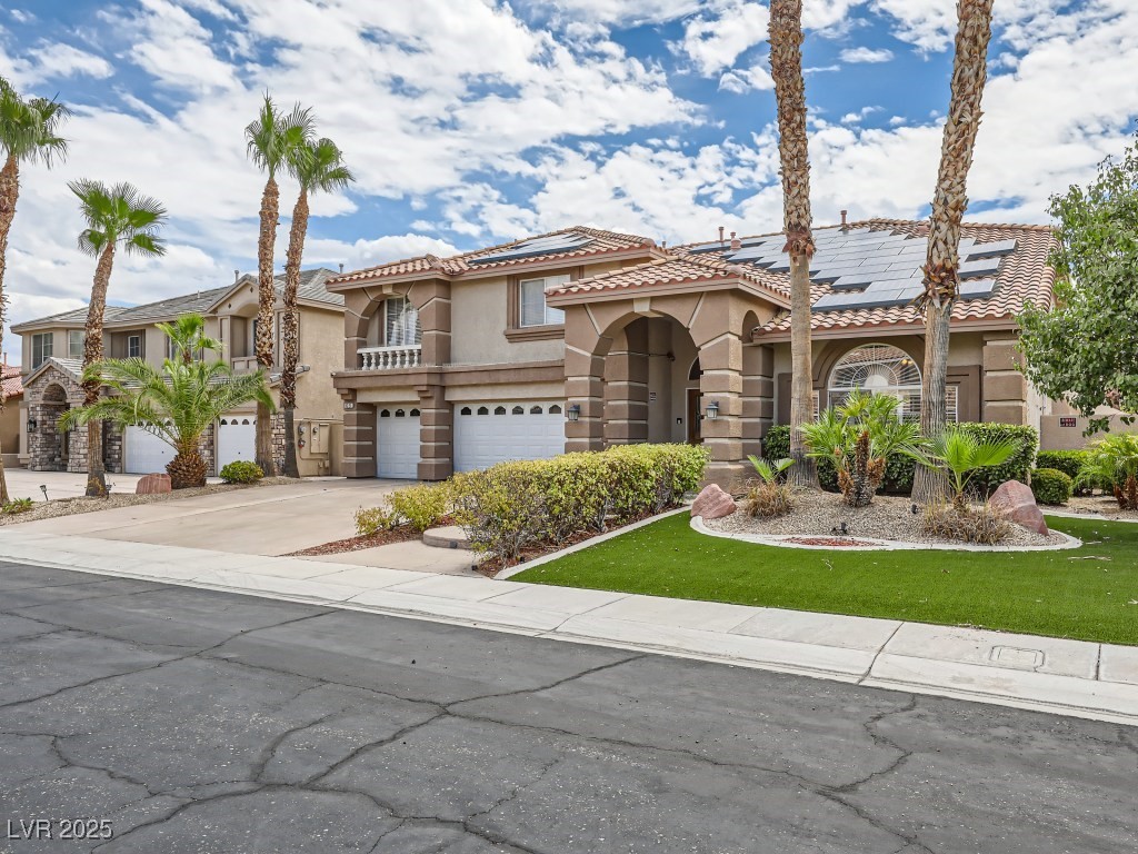 1221 Fragrant Spruce Avenue Las Vegas, NV 89123 - Photo 3 of 59 Mediterranean / spanish-style home with stucco siding, concrete driveway, an attached garage, a tiled roof, and solar panels