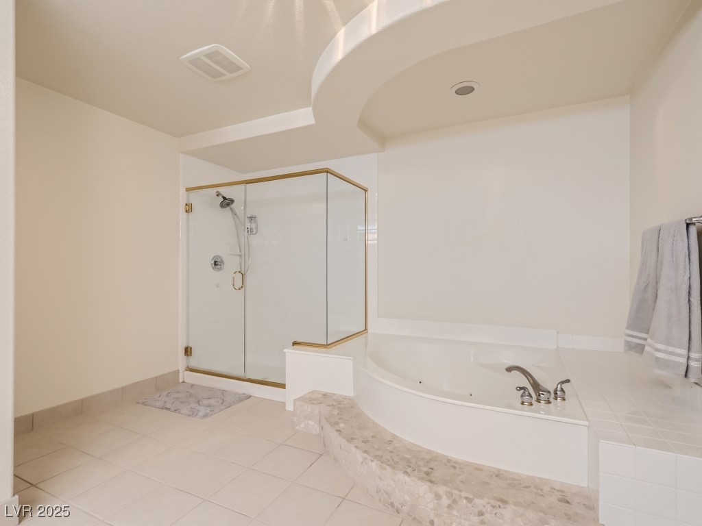 1221 Fragrant Spruce Avenue Las Vegas, NV 89123 - Photo 31 of 59 Primary bathroom with a jetted tub, light tile patterned floors, and a stall shower