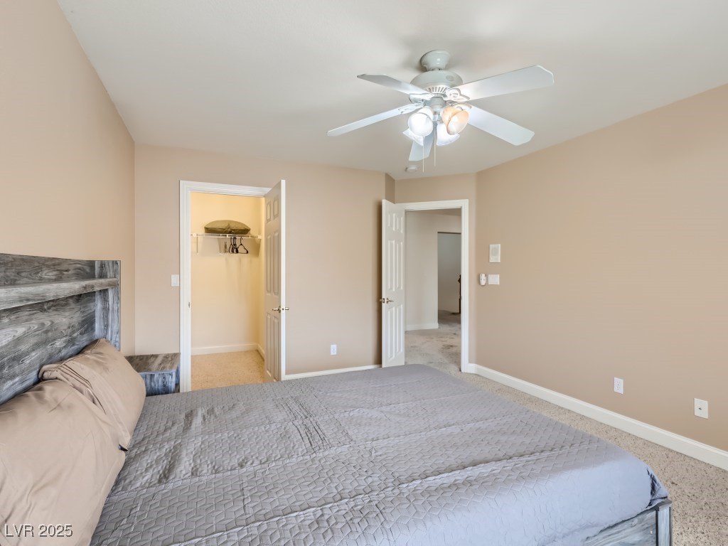 1221 Fragrant Spruce Avenue Las Vegas, NV 89123 - Photo 37 of 59 Bedroom with a walk-in closet, light carpet, and ceiling fan with light