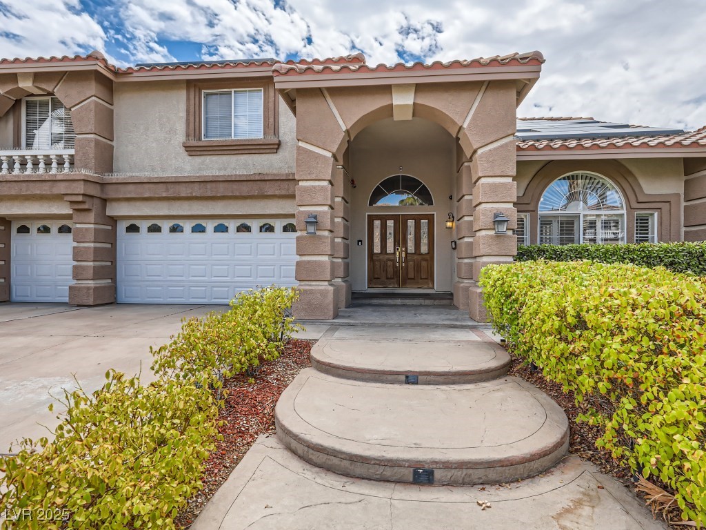1221 Fragrant Spruce Avenue Las Vegas, NV 89123 - Photo 4 of 59 Property entrance featuring stucco siding, a tile roof, driveway, and a garage