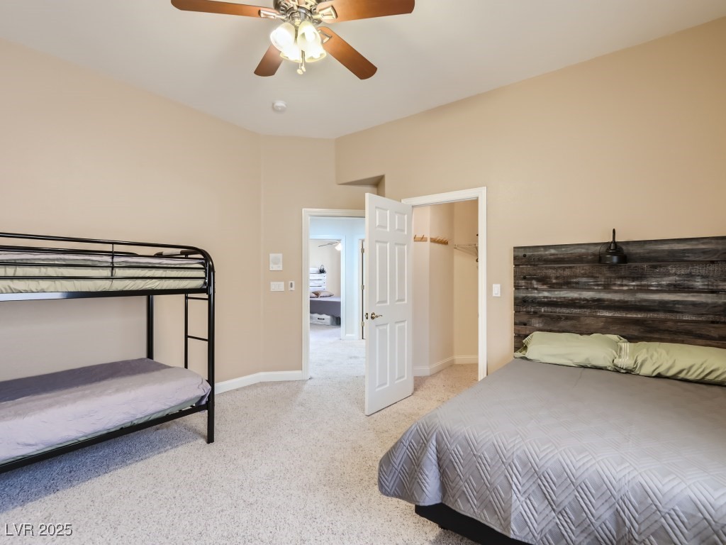 1221 Fragrant Spruce Avenue Las Vegas, NV 89123 - Photo 42 of 59 Bedroom with light carpet, a ceiling fan with light, and a walk in closet