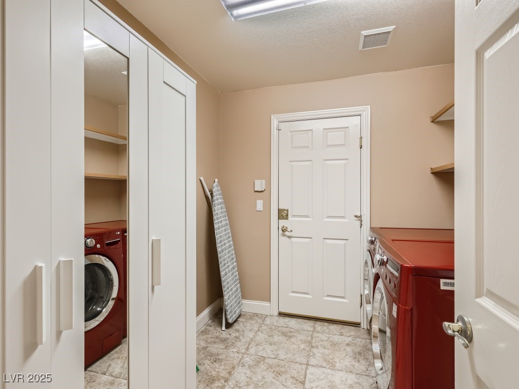 1221 Fragrant Spruce Avenue Las Vegas, NV 89123 - Photo 47 of 59 Laundry room with light tile patterned floors, a textured ceiling, and washing machine and dryer