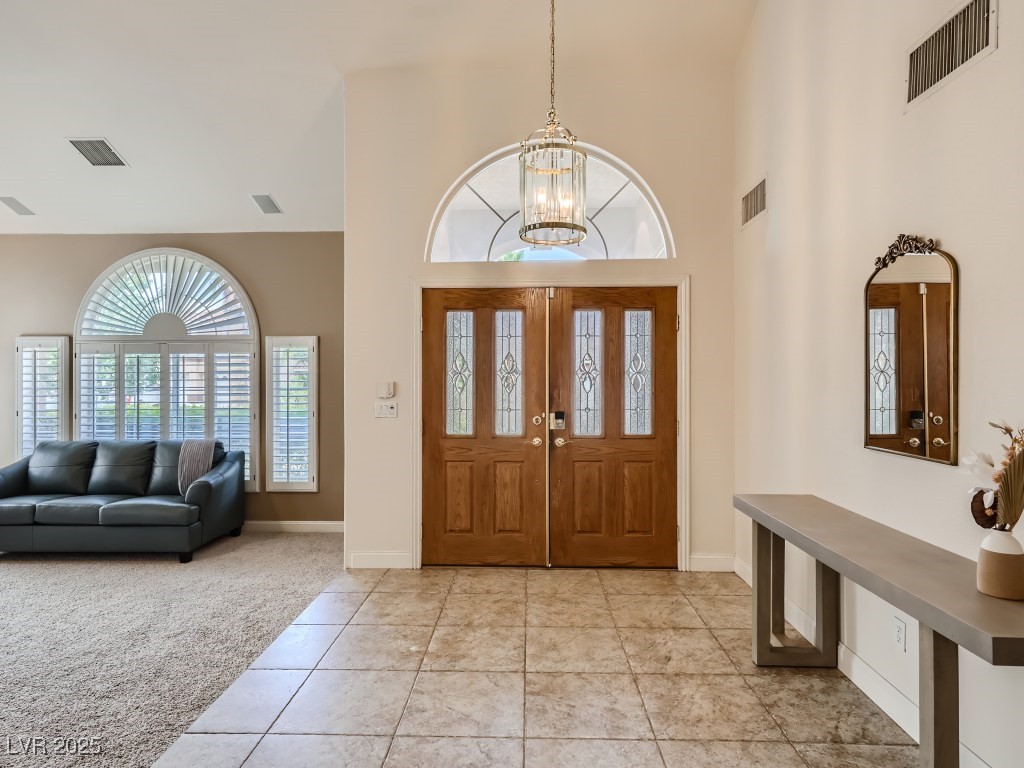 1221 Fragrant Spruce Avenue Las Vegas, NV 89123 - Photo 5 of 59 Entrance foyer featuring light tile patterned flooring, a high ceiling, light carpet, and a chandelier