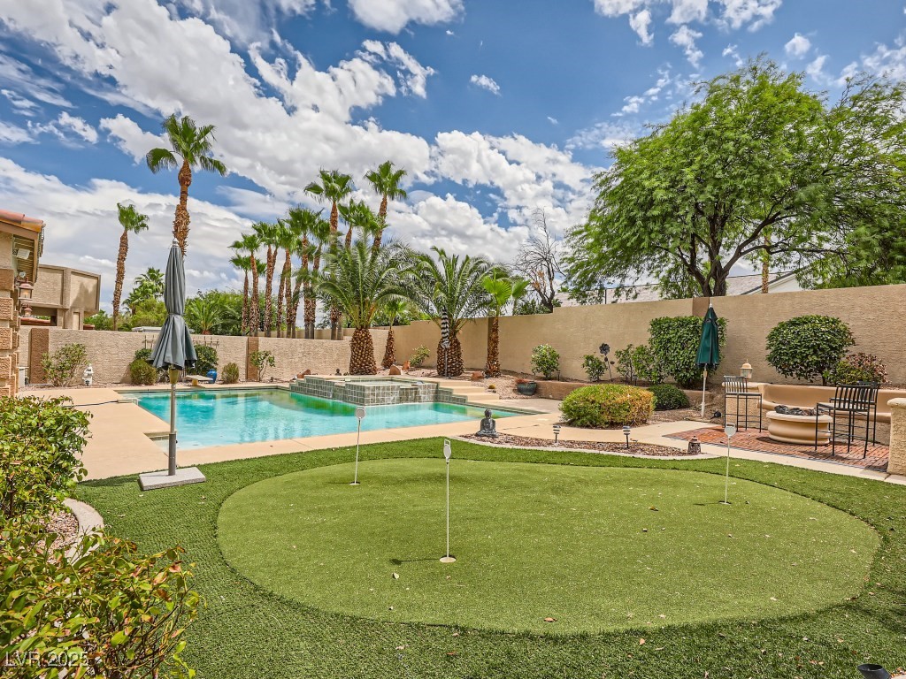 1221 Fragrant Spruce Avenue Las Vegas, NV 89123 - Photo 53 of 59 View of swimming pool with a patio, a putting green, a fenced backyard, and a pool with connected hot tub
