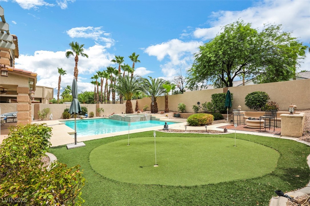 1221 Fragrant Spruce Avenue Las Vegas, NV 89123 - Photo 57 of 59 View of pool with a patio area, an area to practice putting, a fenced backyard, and a pool with connected hot tub