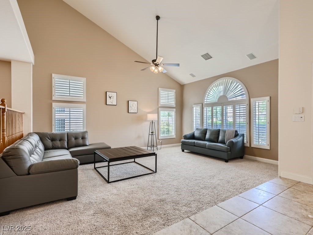 1221 Fragrant Spruce Avenue Las Vegas, NV 89123 - Photo 6 of 59 Family room with high vaulted ceiling, light tile patterned floors, light carpet, shutters, and a ceiling fan with light