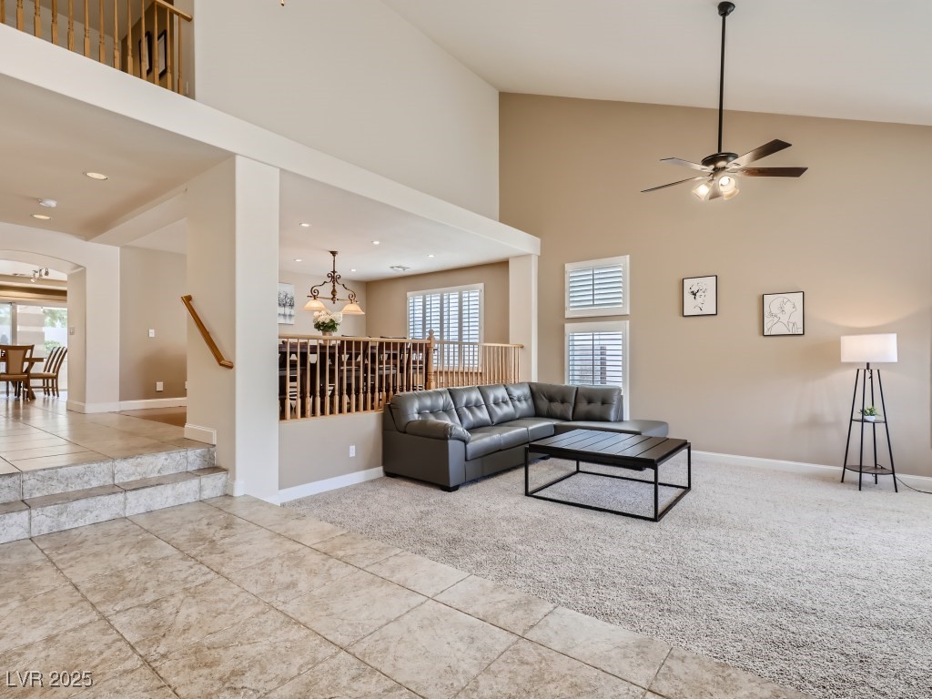 1221 Fragrant Spruce Avenue Las Vegas, NV 89123 - Photo 8 of 59 Family room with high vaulted ceiling, light tile patterned floors, light carpet, shutters, and a ceiling fan with light
