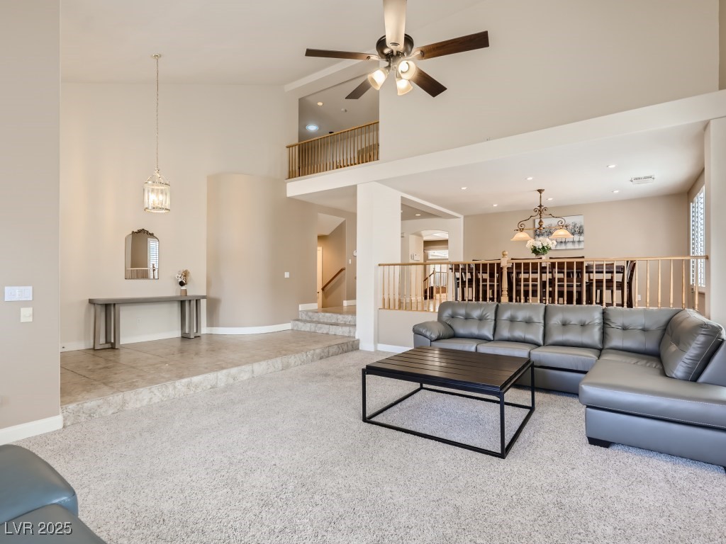 1221 Fragrant Spruce Avenue Las Vegas, NV 89123 - Photo 9 of 59 Family room with high vaulted ceiling, light tile patterned floors, light carpet, shutters, and a ceiling fan with light