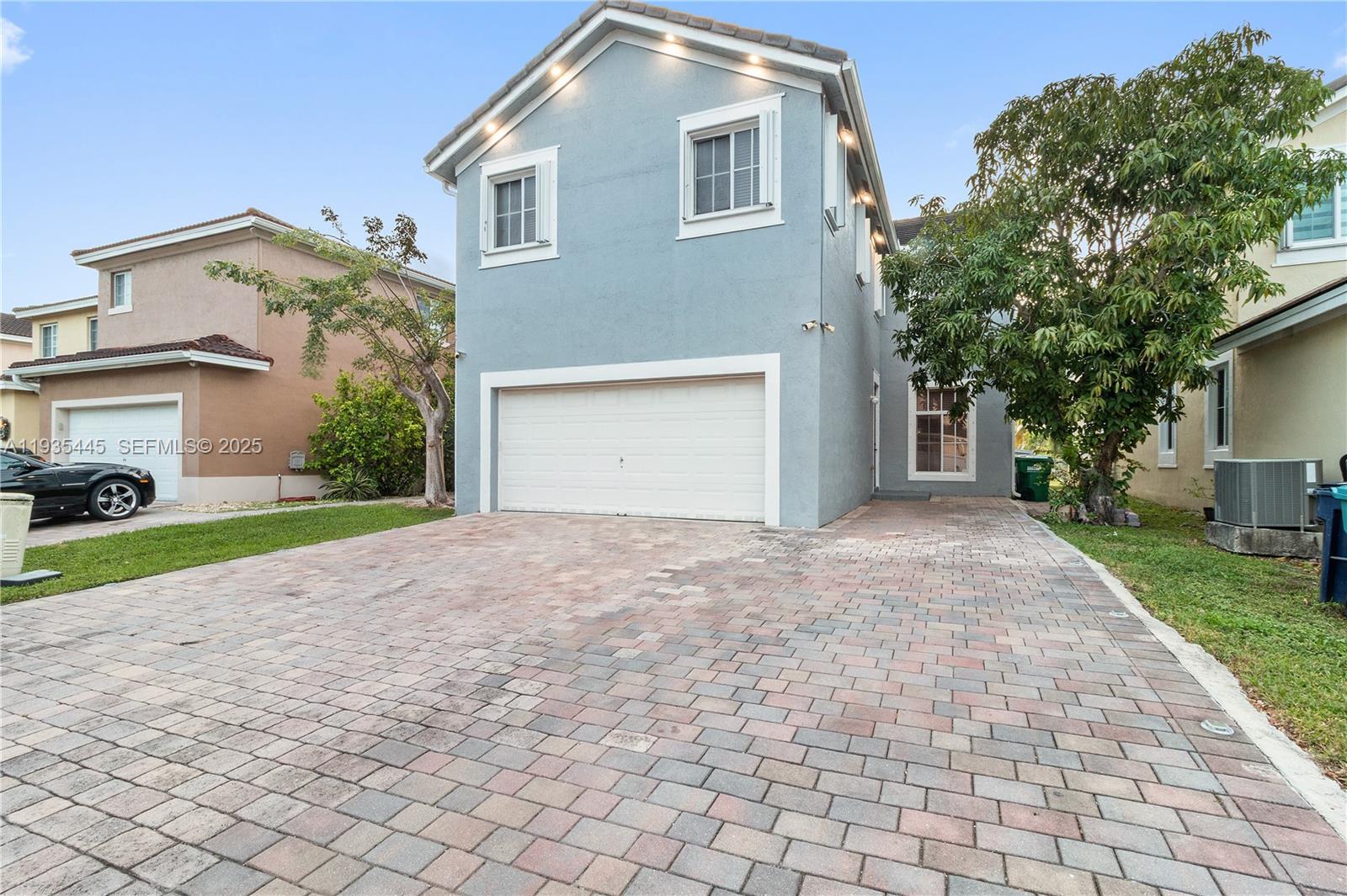 27049 Southwest 142nd Avenue Homestead, FL 33032 - Photo 2 of 36 a front view of a house with a yard and a garage
