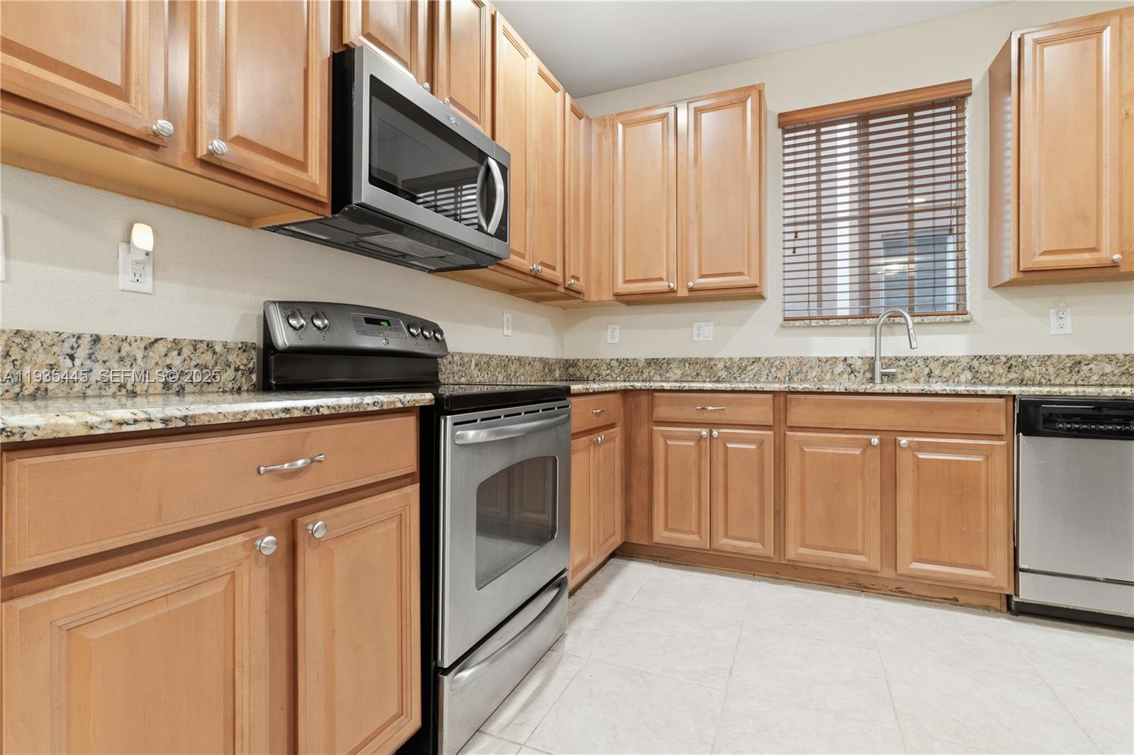27049 Southwest 142nd Avenue Homestead, FL 33032 - Photo 22 of 36 a kitchen with stainless steel appliances granite countertop a sink a stove and cabinets