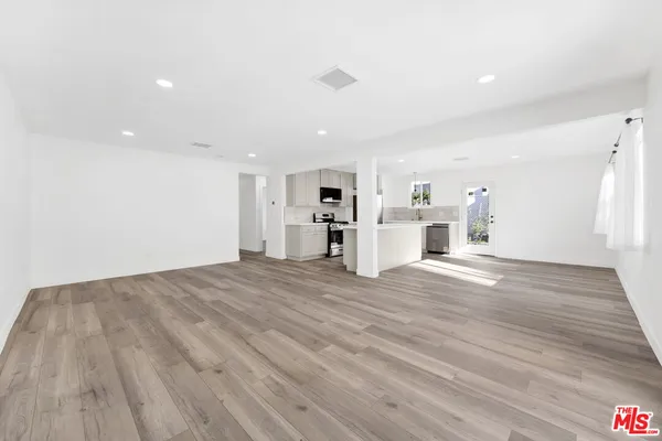 a view of empty room with wooden floor