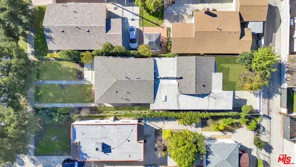an aerial view of residential houses with outdoor space and parking