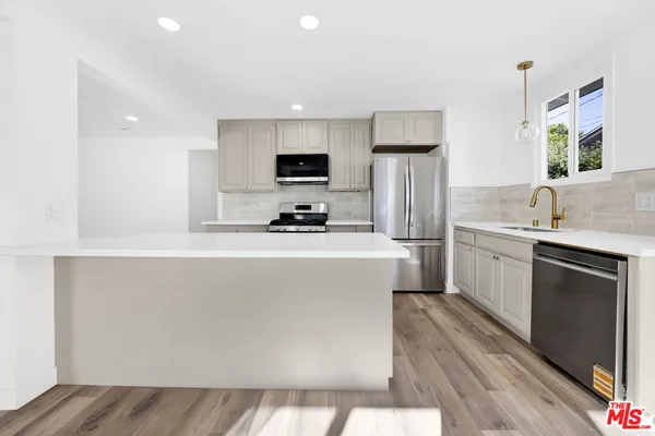 a kitchen with a sink cabinets and stainless steel appliances