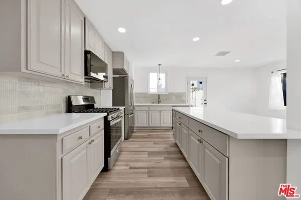 a large kitchen with stainless steel appliances lots of counter space sink and cabinets