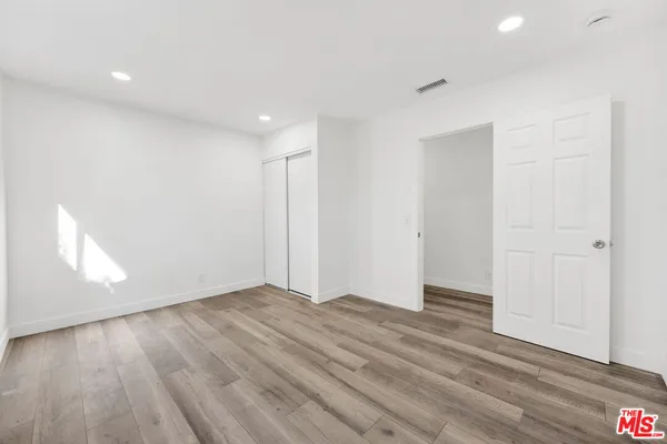 a view of an empty room with wooden floor