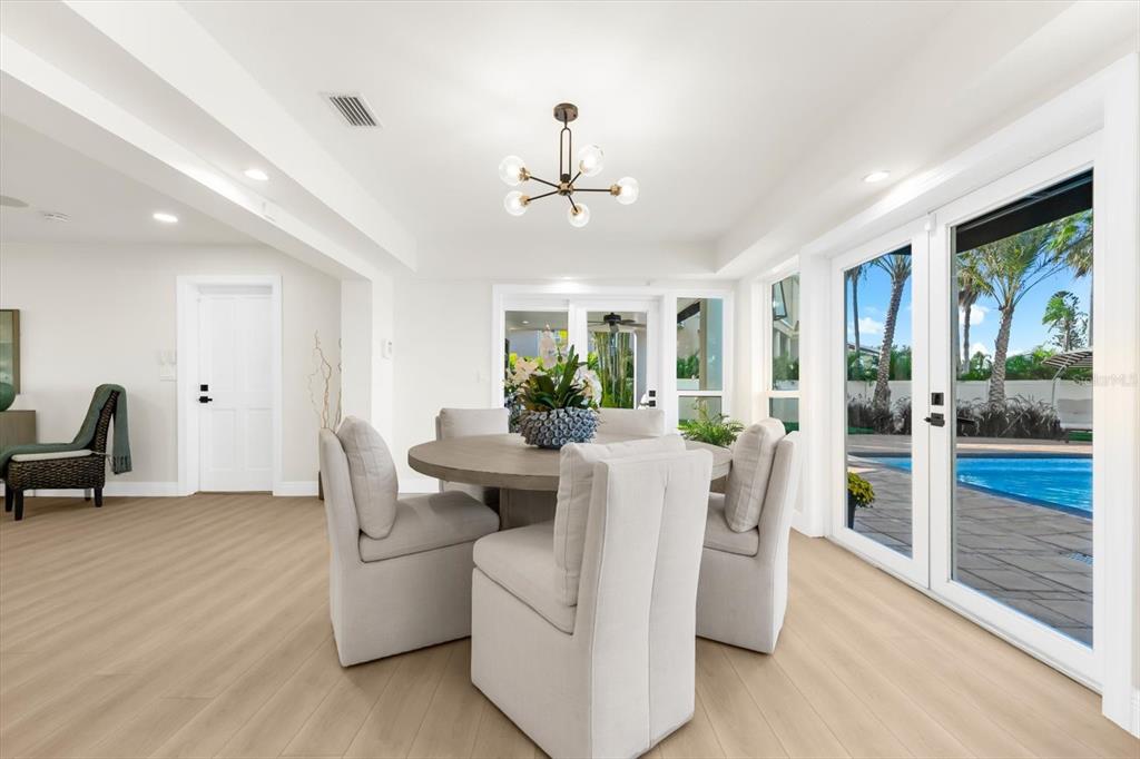 16895 1st Street East North Redington Beach, FL 33708 - Photo 20 of 97 a living room with furniture a flat screen tv and a floor to ceiling window