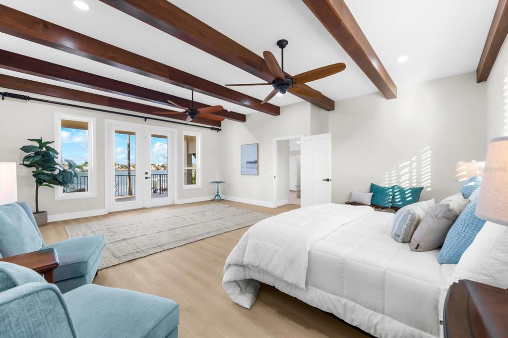 16895 1st Street East North Redington Beach, FL 33708 - Photo 41 of 96 a spacious bedroom with a bed a couch and potted plant on the dresser