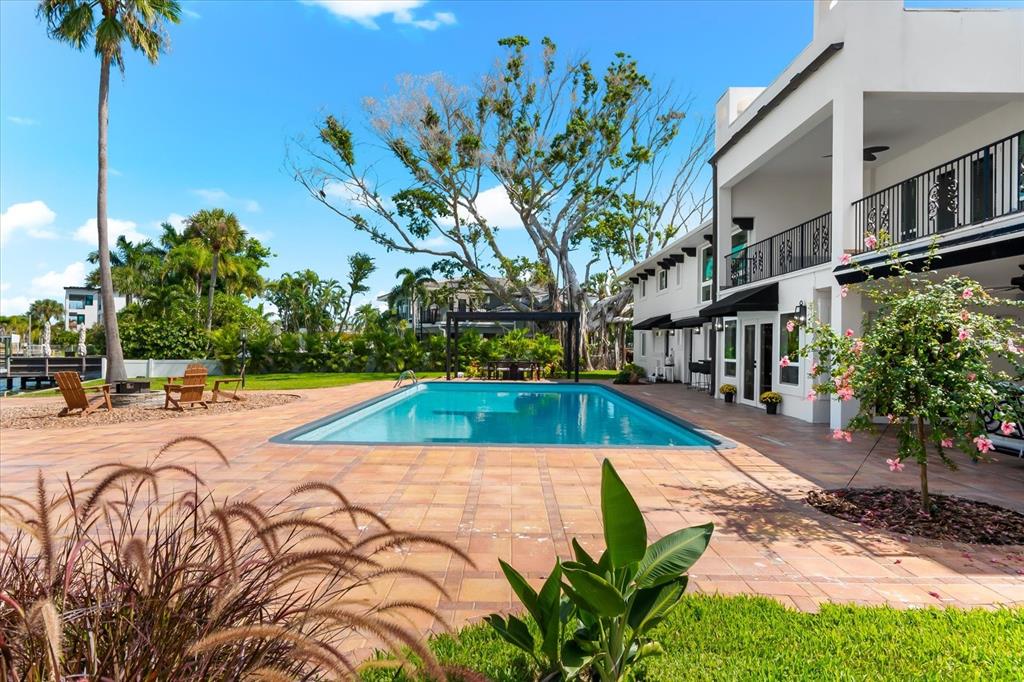 16895 1st Street East North Redington Beach, FL 33708 - Photo 65 of 97 a view of a swimming pool with a lounge chair