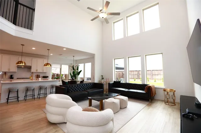 a living room with furniture kitchen view and a large window