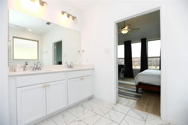 a en suite bathroom with a double vanity sink and a mirror