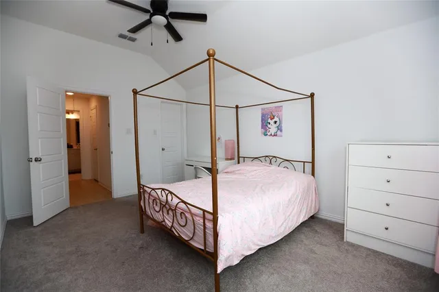 a bedroom with a bed a ceiling fan and a closet