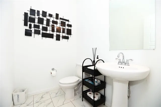 a bathroom with a sink toilet and a mirror