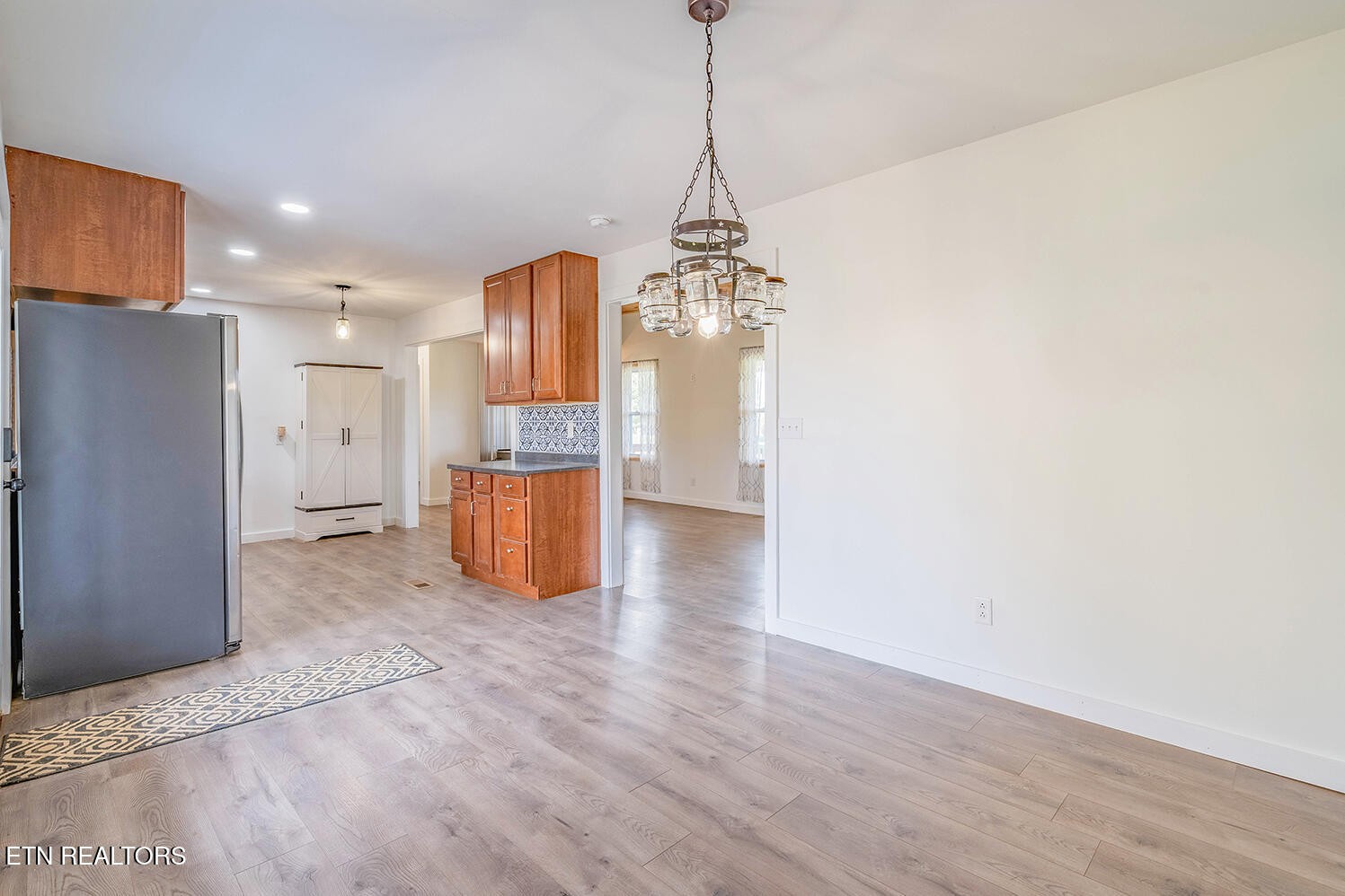 5113 Poplar Springs Road Greeneville, TN 37743 - Photo 10 of 40 a view of a kitchen with a refrigerator a ceiling fan and a wooden floor