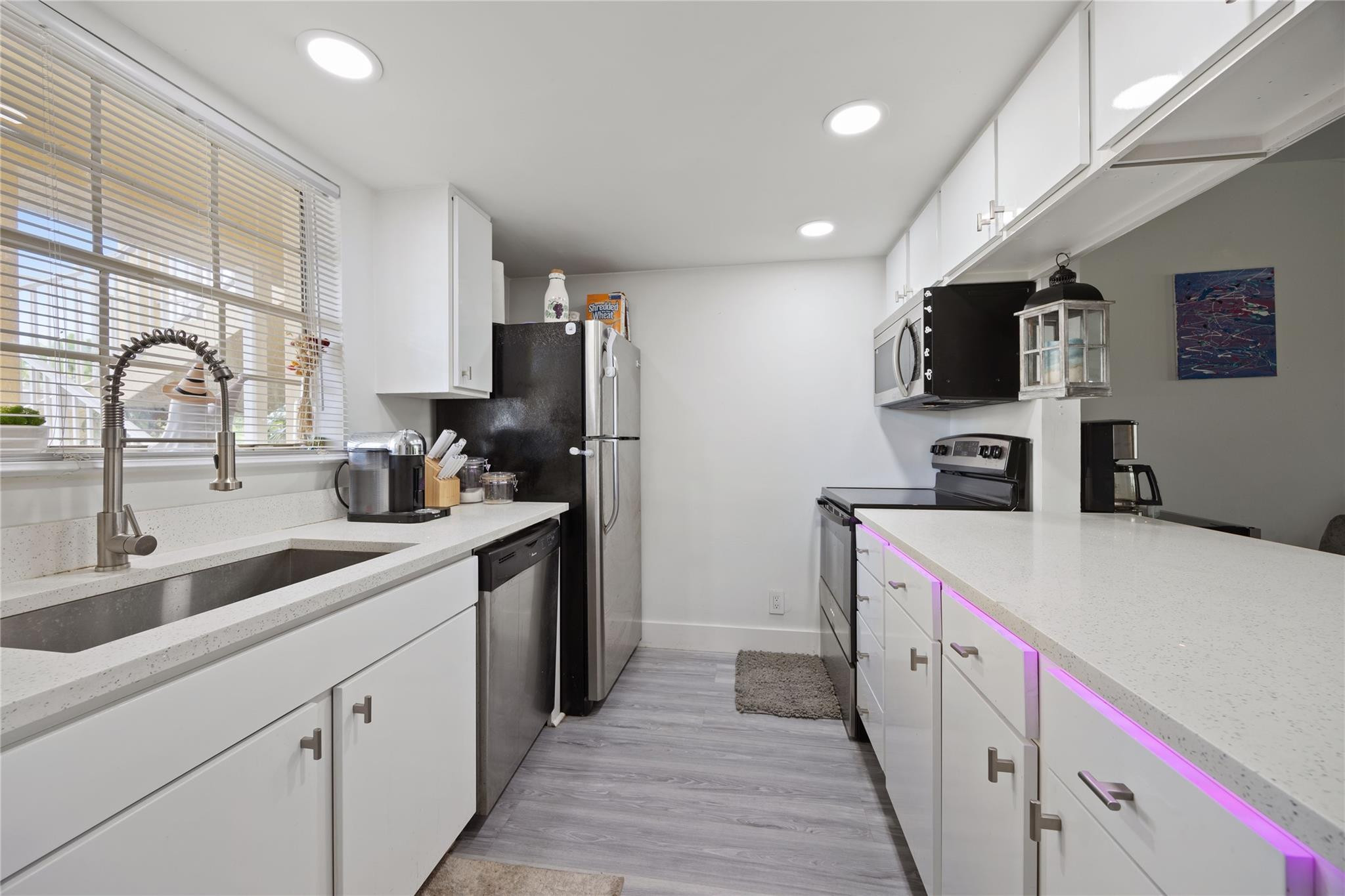 6332 La Costa Drive, Unit B Boca Raton, FL 33433 - Photo 5 of 13 a kitchen with kitchen island granite countertop a sink and a refrigerator