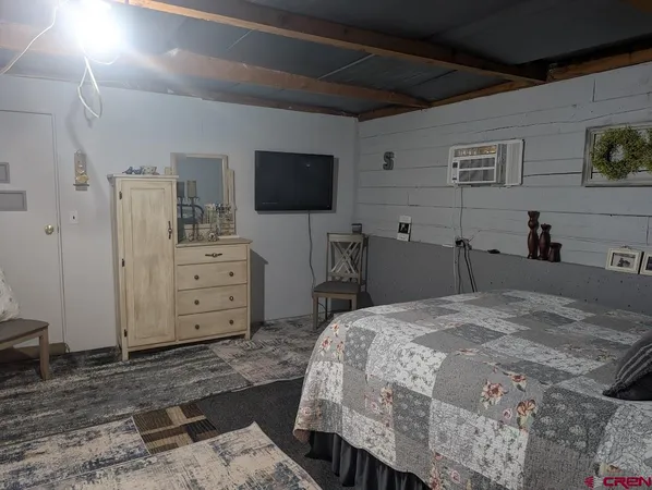 a bedroom with a bed and flat screen tv