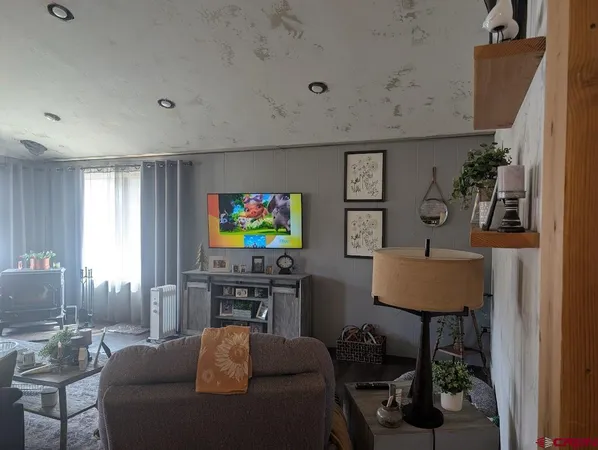 a living room with furniture a window and a flat screen tv