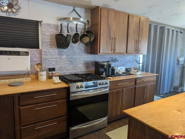 a kitchen with a stove cabinets and wooden floor