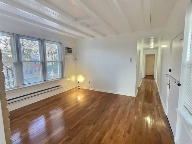 a view of a room with wooden floor and windows