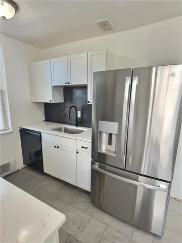 a kitchen with a refrigerator sink and cabinets