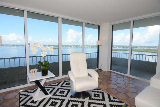 a balcony with couple of chairs and wooden floor