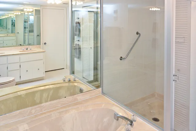 a bathroom with a tub sink and mirror