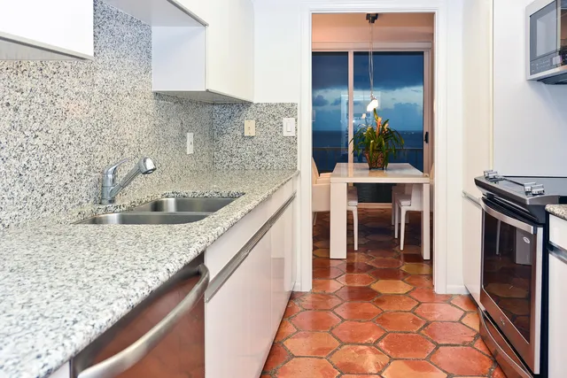 a kitchen with kitchen island granite countertop a sink and a stove